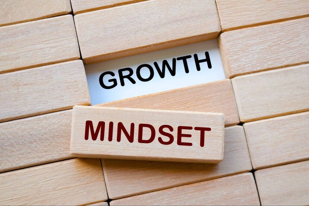 Wooden blocks arranged to display the words MINDSET in red and GROWTH in black, emphasizing the concept of a growth mindset.