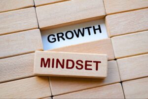 Wooden blocks arranged to display the words MINDSET in red and GROWTH in black, emphasizing the concept of a growth mindset.