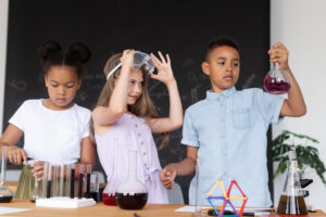 Three children engaging in a science experiment, mixing colorful liquids in glass beakers and test tubes at a laboratory table.